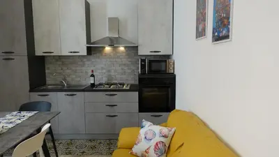 a kitchen with a yellow couch in a small kitchen at Stella di Mare in Balestrate