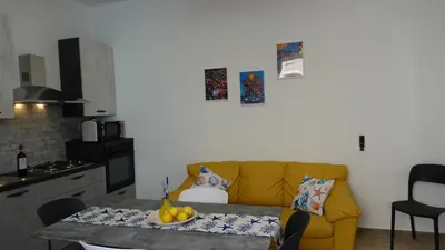 a living room with a yellow couch and a table at Stella di Mare in Balestrate