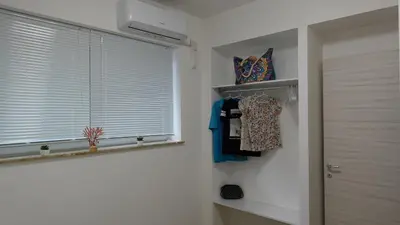 a room with a window and a shelf with clothes at Stella di Mare in Balestrate