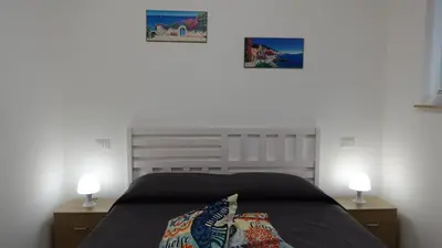 a bedroom with a bed with two night stands and two lamps at Stella di Mare in Balestrate