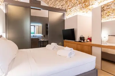 a bedroom with a bed and a desk in a room at Bastione Spasimo Boutique Hotel in Palermo