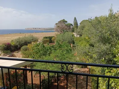 a balcony with a view of a garden and the ocean at Casa VISTA MARE in Macari