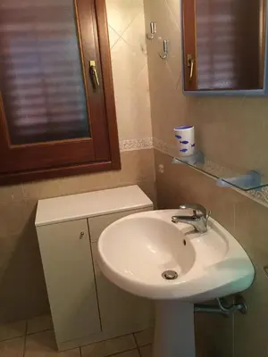 a bathroom with a white sink and a mirror at Casa VISTA MARE in Macari