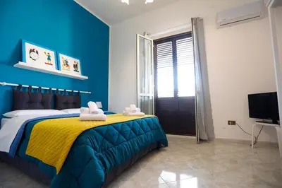 a bedroom with a bed with yellow and blue at Biddizzi Apartment in Palermo