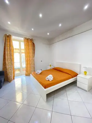 a bedroom with a bed with orange sheets and curtains at Marechiaro Apartments in Palermo