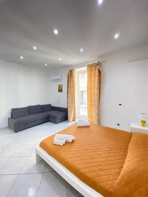 a bedroom with a large bed and a couch at Marechiaro Apartments in Palermo