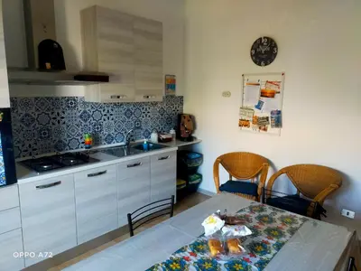 a kitchen with white cabinets and a table with a sink at La Coccinella 
