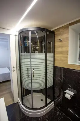 a shower in a bathroom with black tile at Francesco's Home Palermo in Palermo