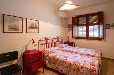 a bedroom with a bed and a red dresser at Villa Piano Vignazza in Scopello