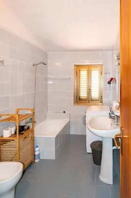 a bathroom with a tub and a sink and a toilet at Villa Piano Vignazza in Scopello