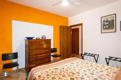 a bedroom with a bed and a dresser and chairs at Villa Piano Vignazza in Scopello
