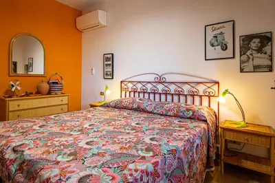 a bedroom with a bed with a colorful bedspread at Villa Piano Vignazza in Scopello
