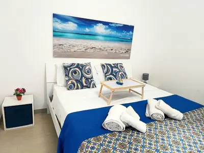 a bedroom with two beds and a table at Dove il mare incontra il Relax!Ampio appartamento Conchiglia Home in Alcamo Marina