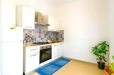 a kitchen with white cabinets and a blue floor mat at Dove il mare incontra il Relax!Ampio appartamento Conchiglia Home in Alcamo Marina
