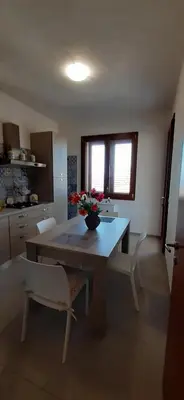 a kitchen with a table with a vase of flowers on it at Casa vacanza Luisa in Alcamo Marina