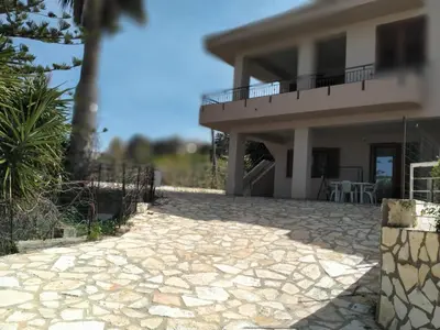 a house with a stone walkway in front of it at Casa vacanza Luisa in Alcamo Marina