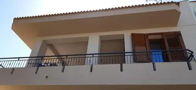 a white house with a balcony and a door at Casa vacanza Luisa in Alcamo Marina