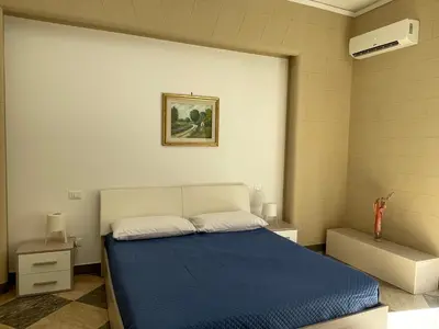a bedroom with a bed with a blue blanket at Grande Sole Siciliano in Palermo