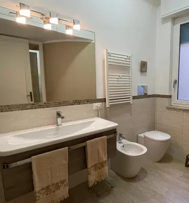 a bathroom with a sink and a toilet and a mirror at Grande Sole Siciliano in Palermo