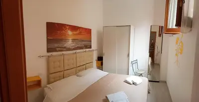 a bedroom with a bed and a painting on the wall at Roberto Guest House in Castellammare del Golfo