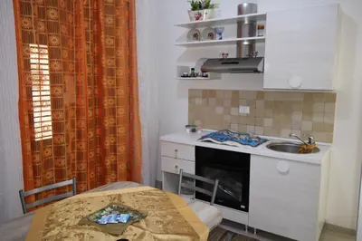 a small kitchen with a sink and a table with a tableablish at Roberto Guest House in Castellammare del Golfo