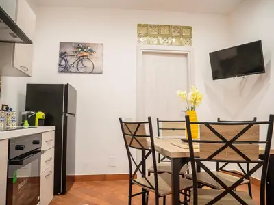 a kitchen with a table and chairs and a refrigerator at Aliva apartment LT in Palermo