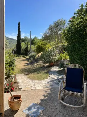 a blue chair sitting in a yard with a view at La Pedrera Rosa/The Pink Pedrera in Balata di Baida