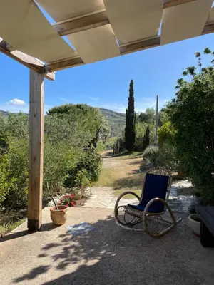 a chair sitting on a porch with a view at La Pedrera Rosa/The Pink Pedrera in Balata di Baida