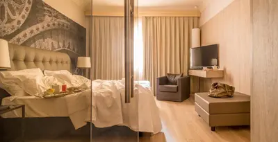 a hotel room with a bed and a tv at Hotel Federico II Central Palace in Palermo