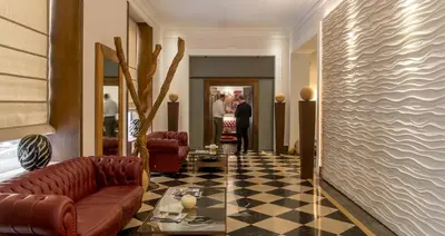 a lobby with a leather couch and a checkerboard floor at Hotel Federico II Central Palace in Palermo