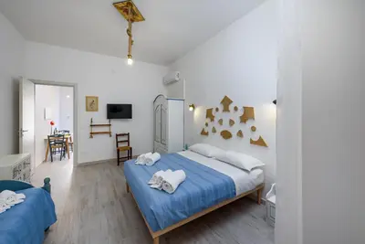 a bedroom with a large bed with blue sheets at CoralBay San Vito lo Capo - Appartamento in San Vito lo Capo