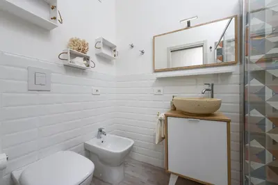 a bathroom with a toilet and a sink and a mirror at CoralBay San Vito lo Capo - Appartamento in San Vito lo Capo