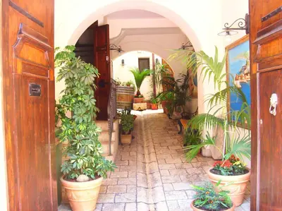 a hallway with a bunch of plants in pots at Locanda Scirocco in Castellammare del Golfo