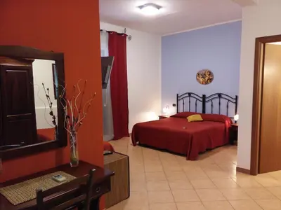 a bedroom with a red bed and blue walls at Locanda Scirocco in Castellammare del Golfo