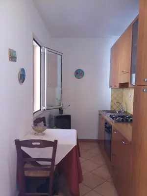 a kitchen with a table and a table and a stove at Locanda Scirocco in Castellammare del Golfo