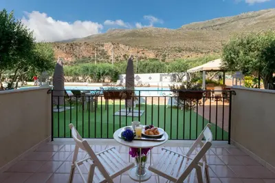 a table with a plate of food on a balcony at Hotel Achibea in San Vito lo Capo