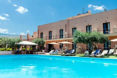 a large swimming pool in front of a building at Hotel Achibea in San Vito lo Capo