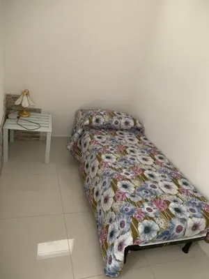 a bedroom with a bed with a bedspread and a table at Casa Enza Partanna Mondello in Palermo