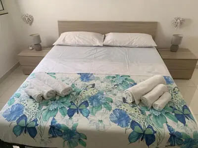 a bedroom with a bed with towels on it at Casa Enza Partanna Mondello in Palermo