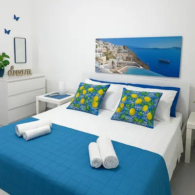 a bedroom with a blue and white bed with pillows at Marea il tuo angolo di paradiso in Sicilia ti aspetta prenota ora e vivi la magia del Mediterraneo in Alcamo Marina