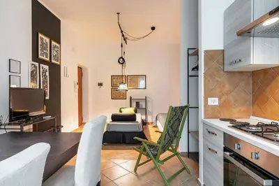 a kitchen and living room with a table and chairs at GuestHost - Ballarò Central Cozy Studio with Balcony in Palermo