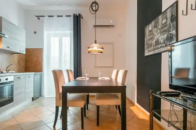 a dining room with a black table and chairs at GuestHost - Ballarò Central Cozy Studio with Balcony in Palermo