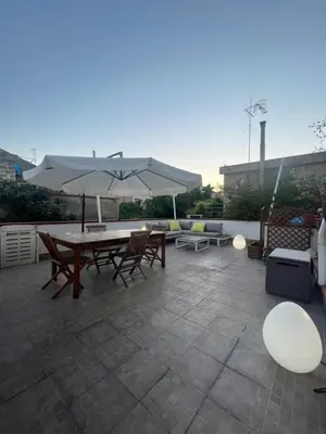 a patio with a table and chairs and an umbrella at Harin House Casa vacanze in Palermo