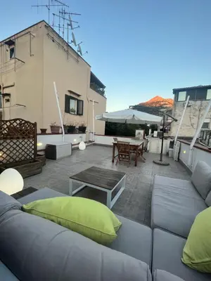 a rooftop patio with a couch and a table at Harin House Casa vacanze in Palermo