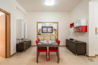 a dining room with a table and red chairs at Villa DellOmbra in Alcamo