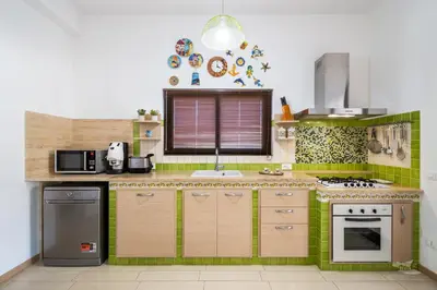 a kitchen with green tiles and a counter top at Villa DellOmbra in Alcamo