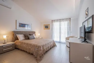 a bedroom with a bed and a flat screen tv at Villa DellOmbra in Alcamo