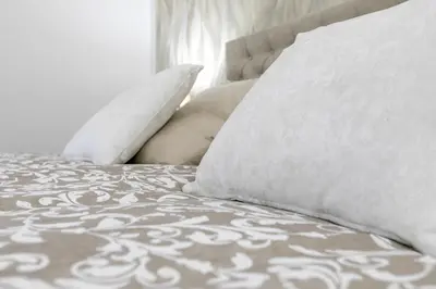 a bed with white pillows and a gray and white blanket at Vittorio Emanuele Charming Central Flats in Palermo