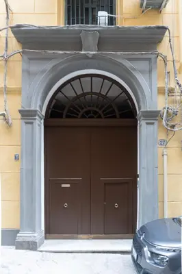 a garage with a brown door in a building at Vittorio Emanuele Charming Central Flats in Palermo
