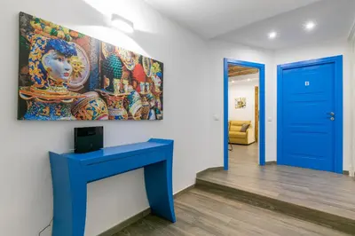 a blue table in a room with a painting on the wall at Vittorio Emanuele Charming Central Flats in Palermo